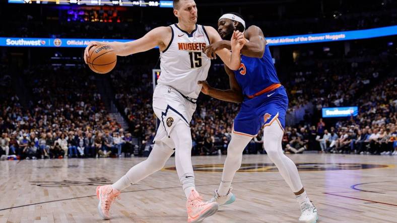 Mar 21, 2024; Denver, Colorado, USA; Denver Nuggets center Nikola Jokic (15) controls the ball as New York Knicks forward Precious Achiuwa (5) guards in the first quarter at Ball Arena. Mandatory Credit: Isaiah J. Downing-USA TODAY Sports