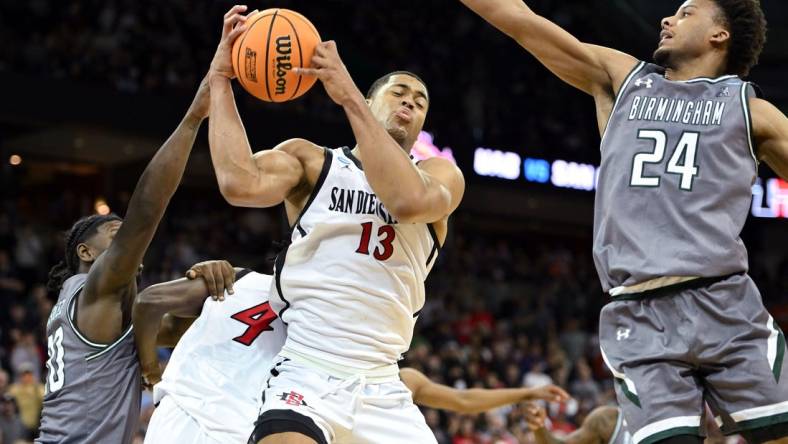 Mar 22, 2024; Spokane, WA, USA; San Diego State Aztecs forward Jaedon LeDee (13) rebounds the ball against UAB Blazers guard Efrem Johnson (24)  during the second half in the first round of the 2024 NCAA Tournament at Spokane Veterans Memorial Arena. Mandatory Credit: James Snook-USA TODAY Sports