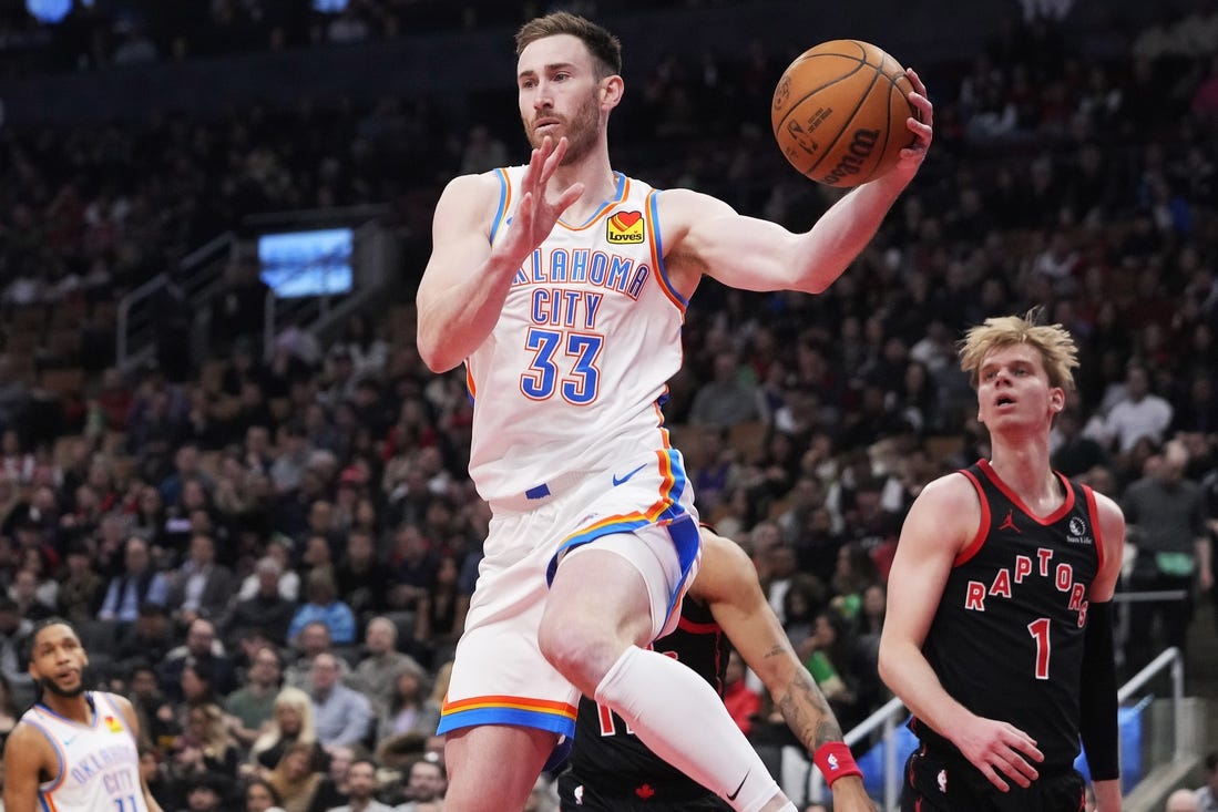 Mar 22, 2024; Toronto, Ontario, CAN; Oklahoma City Thunder forward Gordon Hayward (33) goes to pass the ball as Toronto Raptors guard Gradey Dick (1) looks on during the first half at Scotiabank Arena. Mandatory Credit: John E. Sokolowski-USA TODAY Sports