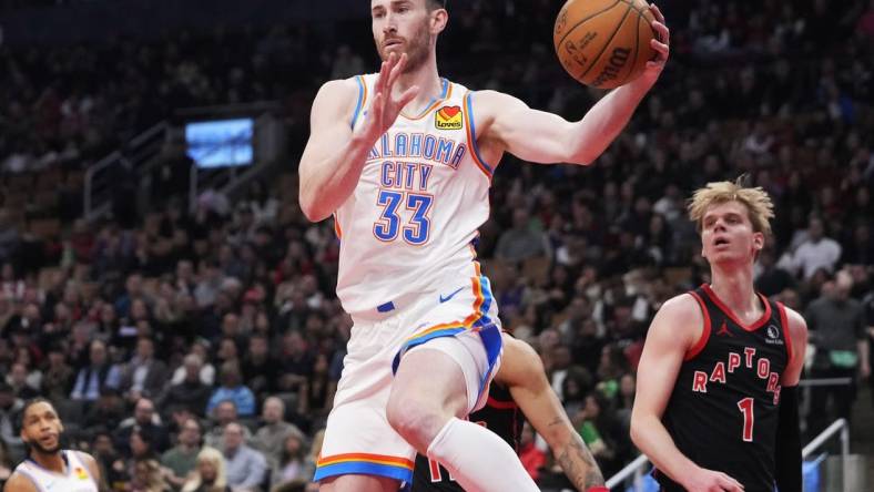 Mar 22, 2024; Toronto, Ontario, CAN; Oklahoma City Thunder forward Gordon Hayward (33) goes to pass the ball as Toronto Raptors guard Gradey Dick (1) looks on during the first half at Scotiabank Arena. Mandatory Credit: John E. Sokolowski-USA TODAY Sports