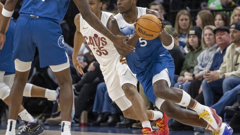 Mar 22, 2024; Minneapolis, Minnesota, USA; Minnesota Timberwolves guard Anthony Edwards (5) receives the ball from Minnesota Timberwolves center Naz Reid (11) against the Cleveland Cavaliers in the first half at Target Center. Mandatory Credit: Jesse Johnson-USA TODAY Sports