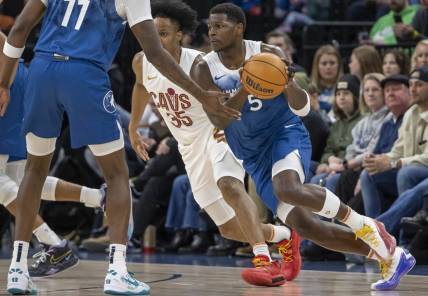 Mar 22, 2024; Minneapolis, Minnesota, USA; Minnesota Timberwolves guard Anthony Edwards (5) receives the ball from Minnesota Timberwolves center Naz Reid (11) against the Cleveland Cavaliers in the first half at Target Center. Mandatory Credit: Jesse Johnson-USA TODAY Sports