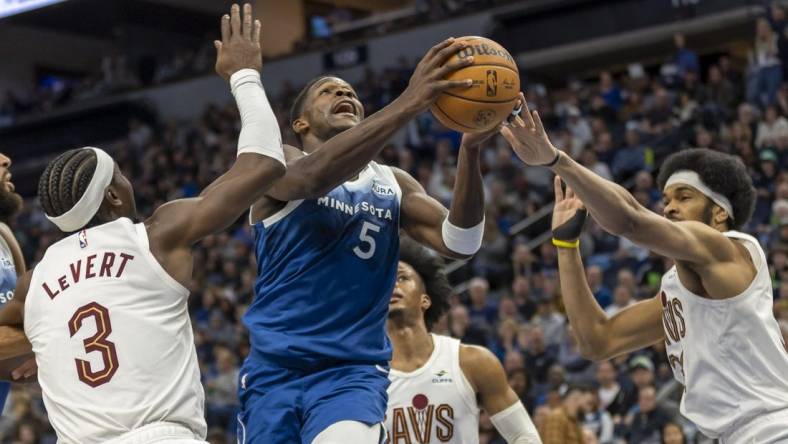 Mar 22, 2024; Minneapolis, Minnesota, USA; Minnesota Timberwolves guard Anthony Edwards (5) drives to the basket past Cleveland Cavaliers center Jarrett Allen (31) and Cleveland Cavaliers guard Caris LeVert (3) in the second half at Target Center. Mandatory Credit: Jesse Johnson-USA TODAY Sports