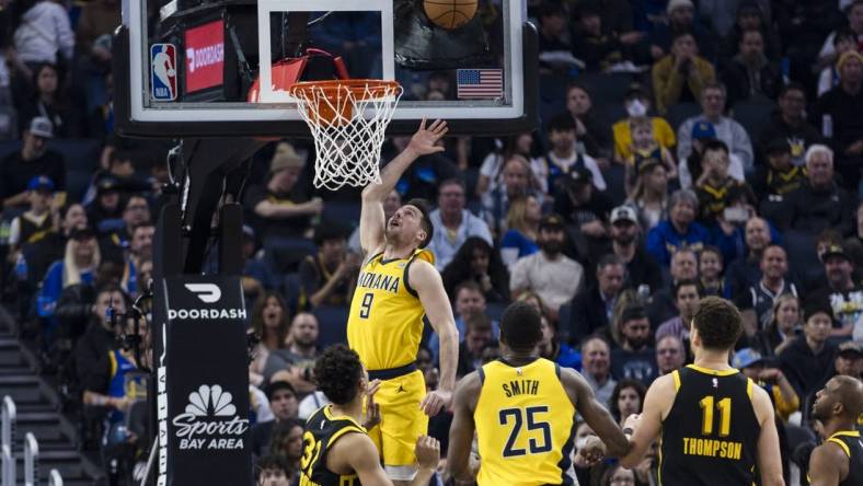 Mar 22, 2024; San Francisco, California, USA; Indiana Pacers guard T.J. McConnell (9) shoots in front of forward Jalen Smith (25) and Golden State Warriors center Trayce Jackson-Davis (32) during the first half at Chase Center. Mandatory Credit: John Hefti-USA TODAY Sports