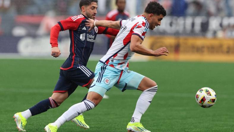 Mar 23, 2024; Foxborough, Massachusetts, USA; Chicago Fire FC defender Allan Arigoni (27) plays the ball defended by New England Revolution midfielder Nacho Gil (21) in the first half at Gillette Stadium. Mandatory Credit: Paul Rutherford-USA TODAY Sports