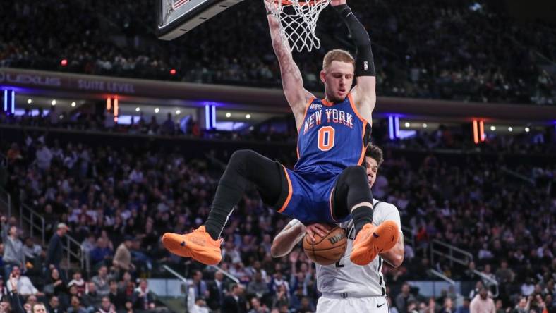 Mar 23, 2024; New York, New York, USA;  New York Knicks guard Donte DiVincenzo (0) dunks in front of Brooklyn Nets forward Cameron Johnson (2) in the fourth quarter at Madison Square Garden. Mandatory Credit: Wendell Cruz-USA TODAY Sports