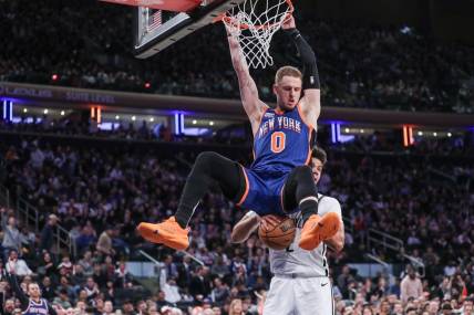 Mar 23, 2024; New York, New York, USA;  New York Knicks guard Donte DiVincenzo (0) dunks in front of Brooklyn Nets forward Cameron Johnson (2) in the fourth quarter at Madison Square Garden. Mandatory Credit: Wendell Cruz-USA TODAY Sports
