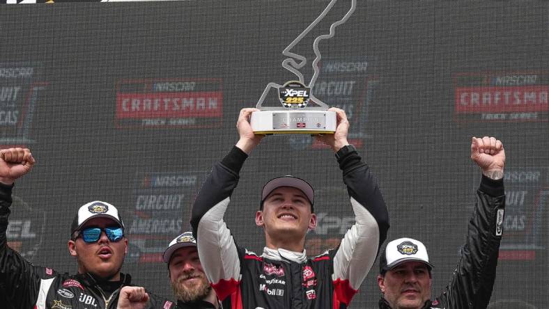 Corey Heim (11) holds up the trophy after wining the NASCAR Craftsman Truck Series Xpel 225 at the Circuit of the Americas on Saturday, March 23, 2024 in Austin.