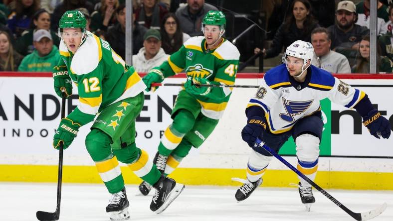 Mar 23, 2024; Saint Paul, Minnesota, USA; Minnesota Wild left wing Matt Boldy (12) skates with the puck as St. Louis Blues left wing Nathan Walker (26) defends during the third period at Xcel Energy Center. Mandatory Credit: Matt Krohn-USA TODAY Sports