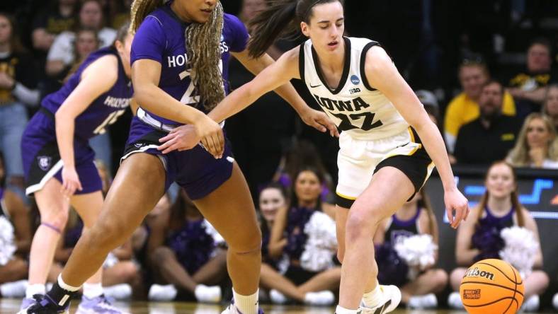 Iowa's Caitlin Clark dribbles as Holy Cross' Simone Foreman defends in a first-round NCAA Tournament game on Saturday.