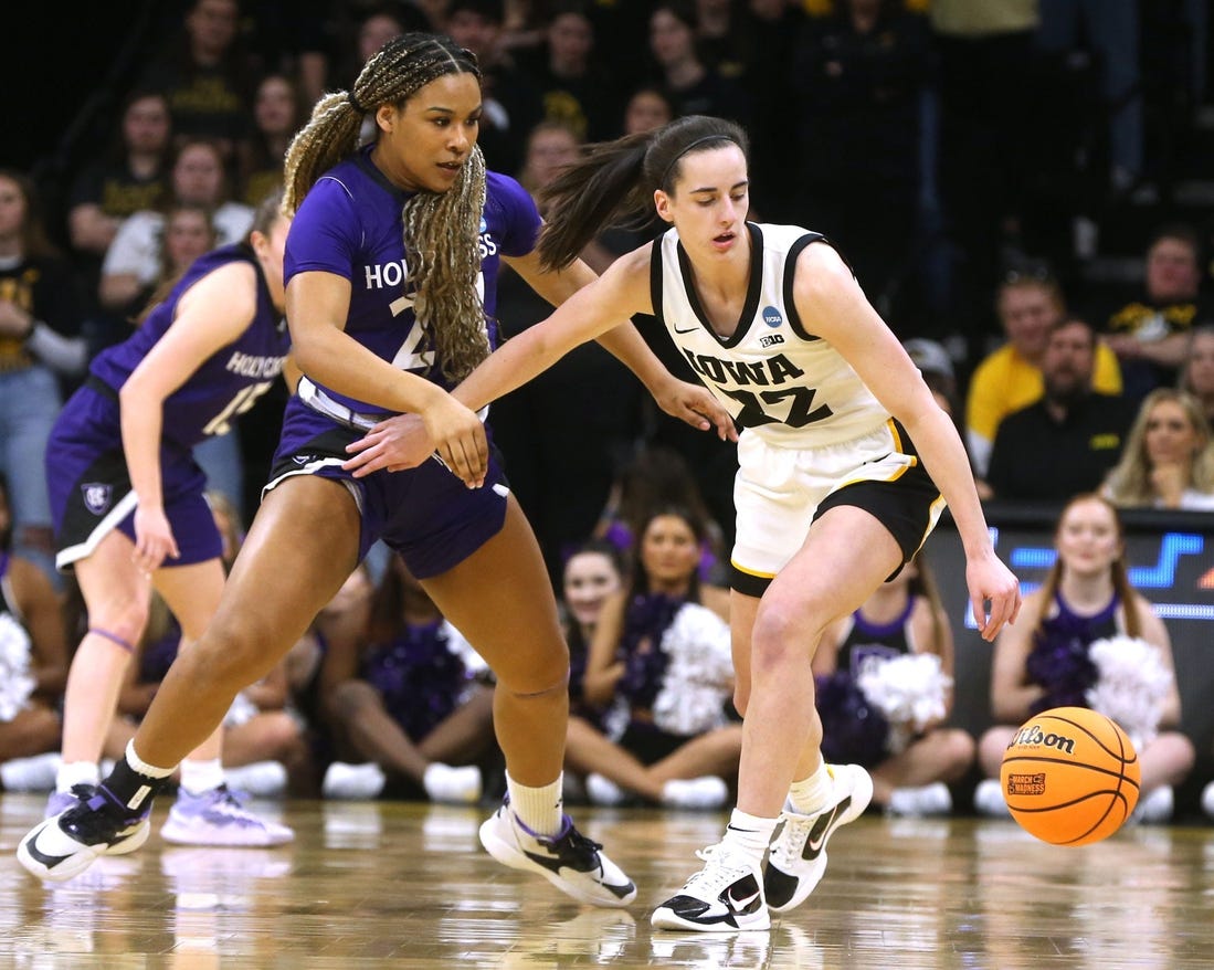 Iowa's Caitlin Clark dribbles as Holy Cross' Simone Foreman defends in a first-round NCAA Tournament game on Saturday.