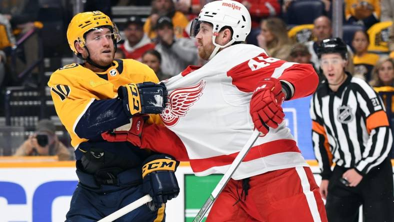 Mar 23, 2024; Nashville, Tennessee, USA; Nashville Predators center Colton Sissons (10) and Detroit Red Wings defenseman Jeff Petry (46) exchange words after a hit during the first period at Bridgestone Arena. Mandatory Credit: Christopher Hanewinckel-USA TODAY Sports