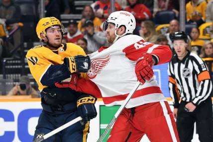 Mar 23, 2024; Nashville, Tennessee, USA; Nashville Predators center Colton Sissons (10) and Detroit Red Wings defenseman Jeff Petry (46) exchange words after a hit during the first period at Bridgestone Arena. Mandatory Credit: Christopher Hanewinckel-USA TODAY Sports