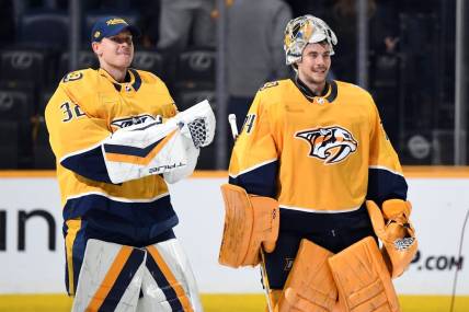 Mar 23, 2024; Nashville, Tennessee, USA; Nashville Predators goaltender Kevin Lankinen (32) and goaltender Juuse Saros (74) skate after a win against the Detroit Red Wings at Bridgestone Arena. Mandatory Credit: Christopher Hanewinckel-USA TODAY Sports