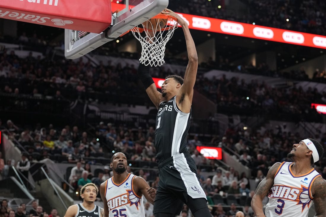 Mar 23, 2024; San Antonio, Texas, USA;  San Antonio Spurs center Victor Wembanyama (1) dunks the ball in front of Phoenix Suns forward Kevin Durant (35) and guard Bradley Beal (3) in the first half at Frost Bank Center. Mandatory Credit: Daniel Dunn-USA TODAY Sports