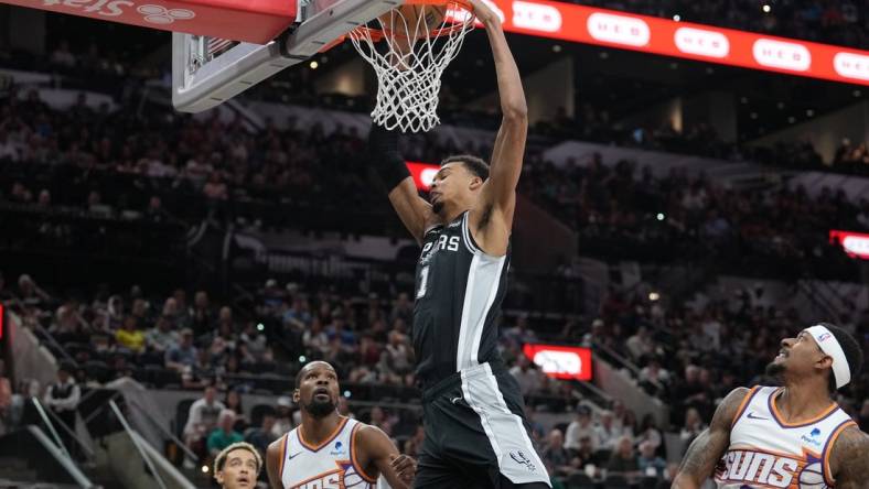 Mar 23, 2024; San Antonio, Texas, USA;  San Antonio Spurs center Victor Wembanyama (1) dunks the ball in front of Phoenix Suns forward Kevin Durant (35) and guard Bradley Beal (3) in the first half at Frost Bank Center. Mandatory Credit: Daniel Dunn-USA TODAY Sports