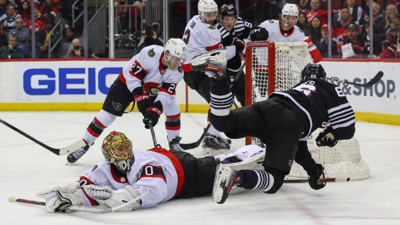 Mar 23, 2024; Newark, New Jersey, USA; Ottawa Senators goaltender Joonas Korpisalo (70) makes a save on New Jersey Devils center Jack Hughes (86) during the second period at Prudential Center. Mandatory Credit: Ed Mulholland-USA TODAY Sports