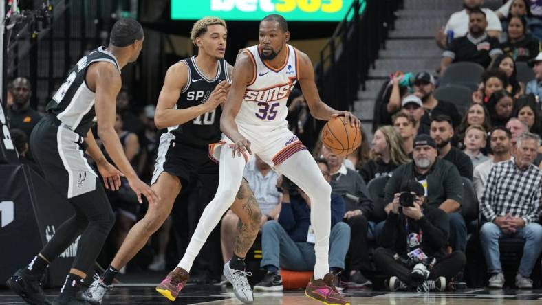 Mar 23, 2024; San Antonio, Texas, USA;  Phoenix Suns forward Kevin Durant (35) backs in against San Antonio Spurs forward Jeremy Sochan (10) in the first half at Frost Bank Center. Mandatory Credit: Daniel Dunn-USA TODAY Sports