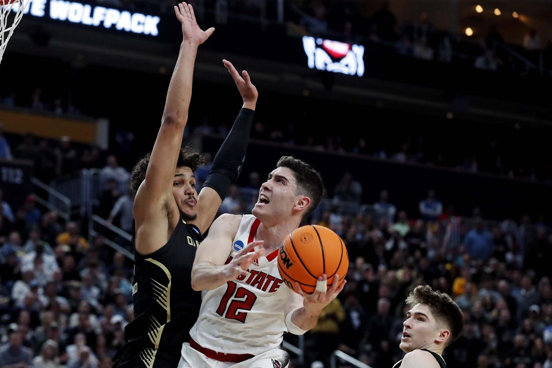 Mar 23, 2024; Pittsburgh, PA, USA; North Carolina State Wolfpack guard Michael O'Connell (12) shoots the ball against Oakland Golden Grizzlies forward Trey Townsend (4) during the second half in the second round of the 2024 NCAA Tournament at PPG Paints Arena. Mandatory Credit: Charles LeClaire-USA TODAY Sports