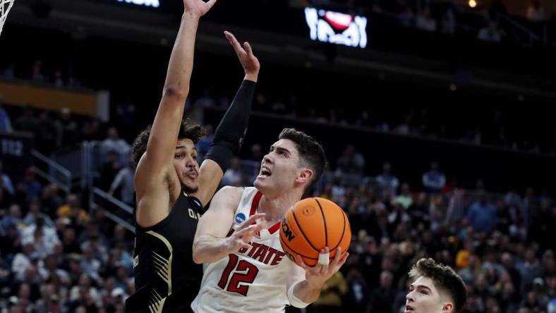 Mar 23, 2024; Pittsburgh, PA, USA; North Carolina State Wolfpack guard Michael O'Connell (12) shoots the ball against Oakland Golden Grizzlies forward Trey Townsend (4) during the second half in the second round of the 2024 NCAA Tournament at PPG Paints Arena. Mandatory Credit: Charles LeClaire-USA TODAY Sports