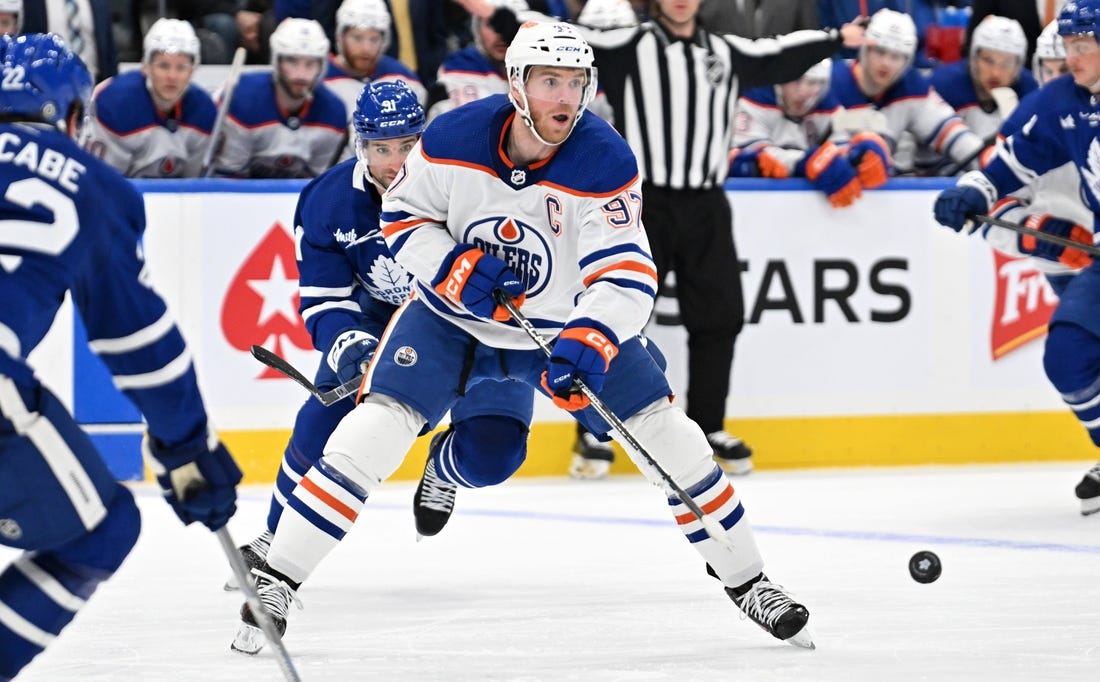 Mar 23, 2024; Toronto, Ontario, CAN; Edmonton Oilers forward Connor McDavid (97) passes the puck against the Toronto Maple Leafs in the second period at Scotiabank Arena. Mandatory Credit: Dan Hamilton-USA TODAY Sports