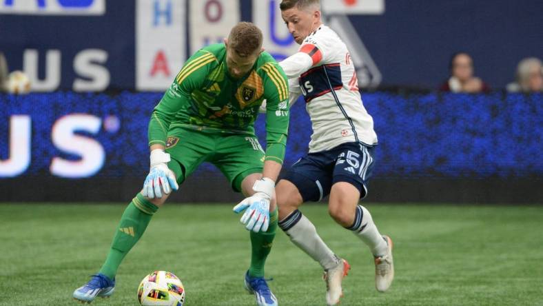 Mar 23, 2024; Vancouver, British Columbia, CAN;  Real Salt Lake goalkeeper Zac MacMath (18) defends against Vancouver Whitecaps FC midfielder Ryan Gauld (25) during the second half at BC Place. Mandatory Credit: Anne-Marie Sorvin-USA TODAY Sports