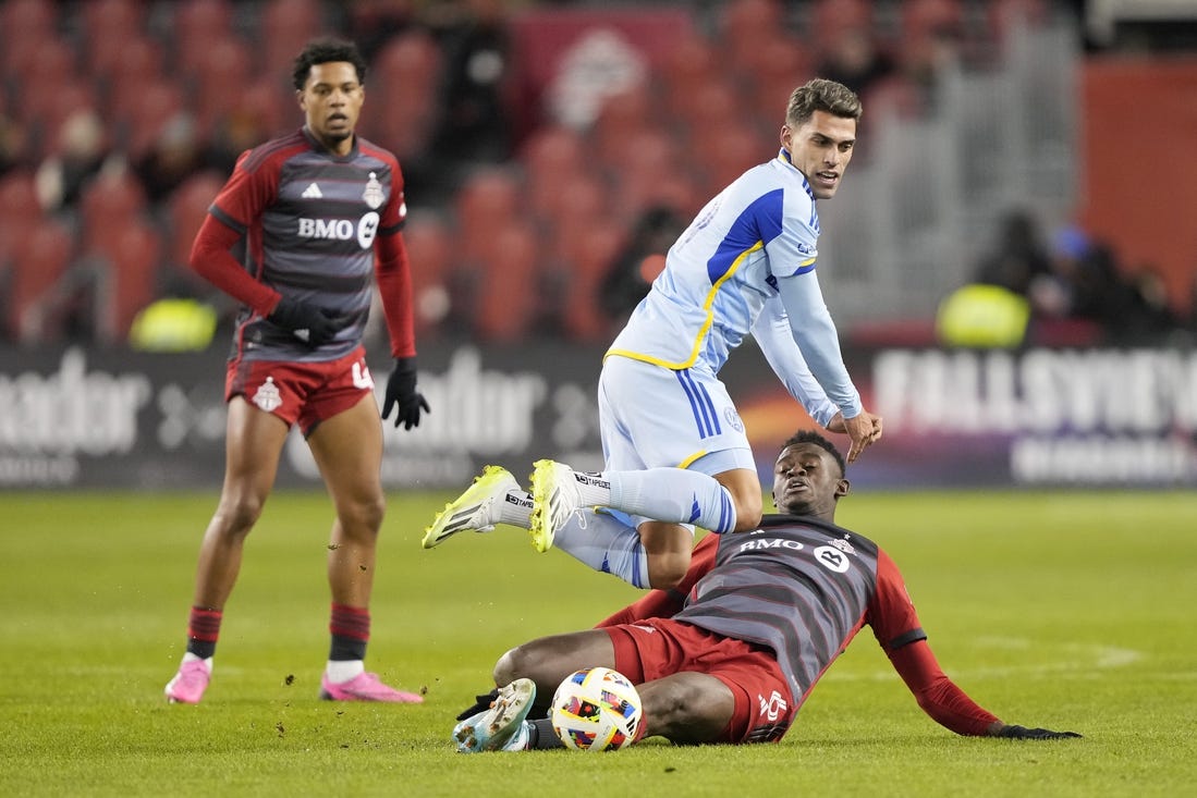 Mar 23, 2024; Toronto, Ontario, USA; Atlanta United forward Daniel Rios (19) fights for the ball Toronto FC defender Aime Mabika (6) during the second half at BMO Field. Mandatory Credit: John E. Sokolowski-USA TODAY Sports