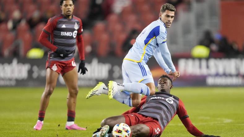 Mar 23, 2024; Toronto, Ontario, USA; Atlanta United forward Daniel Rios (19) fights for the ball Toronto FC defender Aime Mabika (6) during the second half at BMO Field. Mandatory Credit: John E. Sokolowski-USA TODAY Sports