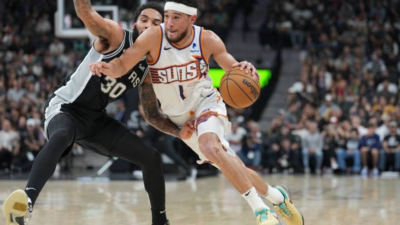 Mar 23, 2024; San Antonio, Texas, USA;  Phoenix Suns guard Devin Booker (1) dribbles against San Antonio Spurs forward Julian Champagnie (30) in the second half at Frost Bank Center. Mandatory Credit: Daniel Dunn-USA TODAY Sports