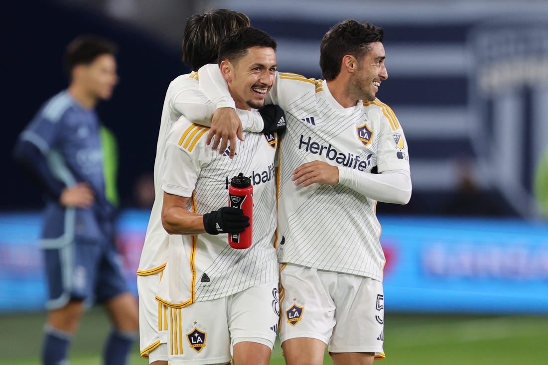 Mar 23, 2024; Kansas City, Kansas, USA; LA Galaxy midfielder Mark Delgado (8) and midfielder Gaston Brugman (5) celebrate after a Galaxy goal against Sporting Kansas City during the second half at Children's Mercy Park. Mandatory Credit: William Purnell-USA TODAY Sports