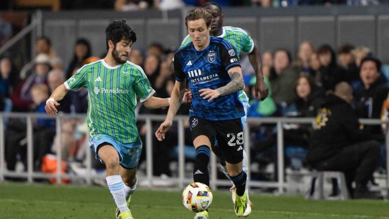 Mar 23, 2024; San Jose, California, USA; San Jose Earthquakes forward Benji Kikanovic (28) dribbles the ball while Seattle Sounders FC midfielder Dylan Teves (99) defends during the second half at PayPal Park. Mandatory Credit: Stan Szeto-USA TODAY Sports