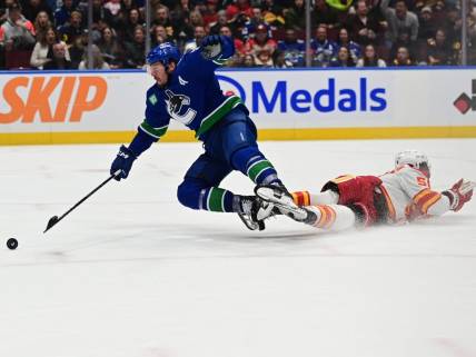 Mar 23, 2024; Vancouver, British Columbia, CAN; Vancouver Canucks forward J.T. Miller (9) checked by Calgary Flames defenseman Olivver Kylington (58) during the third period at Rogers Arena. Mandatory Credit: Simon Fearn-USA TODAY Sports