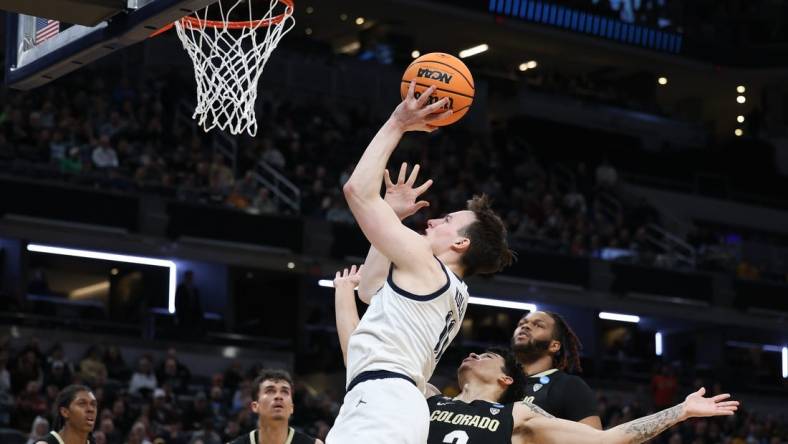 Mar 24, 2024; Indianapolis, IN, USA; Marquette Golden Eagles guard Tyler Kolek (11) shoots over Colorado Buffaloes guard KJ Simpson (2) during the first half at Gainbridge FieldHouse. Mandatory Credit: Trevor Ruszkowski-USA TODAY Sports