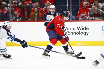 Mar 24, 2024; Washington, District of Columbia, USA; Washington Capitals right wing T.J. Oshie (77) controls the puck as Winnipeg Jets defenseman Dylan Samberg (54) defends during the first period at Capital One Arena. Mandatory Credit: Amber Searls-USA TODAY Sports