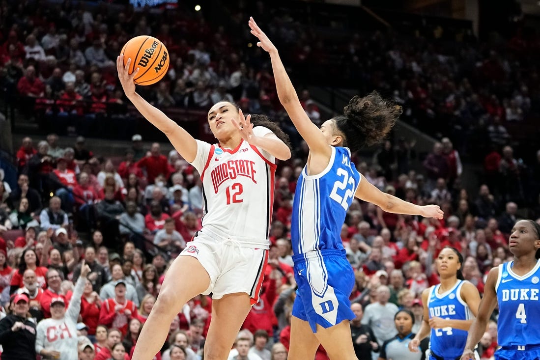 Ohio State guard Celeste Taylor (12) hits a layup around Duke guard Taina Mair (22) during the first half of their women