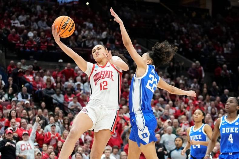 Ohio State guard Celeste Taylor (12) hits a layup around Duke guard Taina Mair (22) during the first half of their women's NCAA Tournament game at Value City Arena.