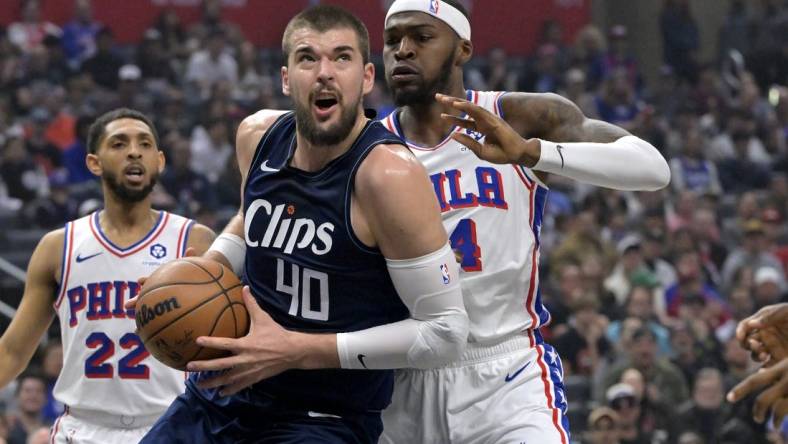 Mar 24, 2024; Los Angeles, California, USA;  Los Angeles Clippers center Ivica Zubac (40) is defended by Philadelphia 76ers forward Paul Reed (44) as he drives to the basket in the first half at Crypto.com Arena. Mandatory Credit: Jayne Kamin-Oncea-USA TODAY Sports