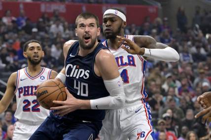 Mar 24, 2024; Los Angeles, California, USA;  Los Angeles Clippers center Ivica Zubac (40) is defended by Philadelphia 76ers forward Paul Reed (44) as he drives to the basket in the first half at Crypto.com Arena. Mandatory Credit: Jayne Kamin-Oncea-USA TODAY Sports