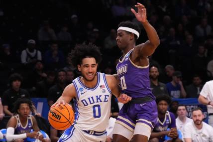 Mar 24, 2024; Brooklyn, NY, USA; Duke Blue Devils guard Jared McCain (0) dribbles the ball past James Madison Dukes guard Xavier Brown (0) in the second round of the 2024 NCAA Tournament  at Barclays Center. Mandatory Credit: Robert Deutsch-USA TODAY Sports