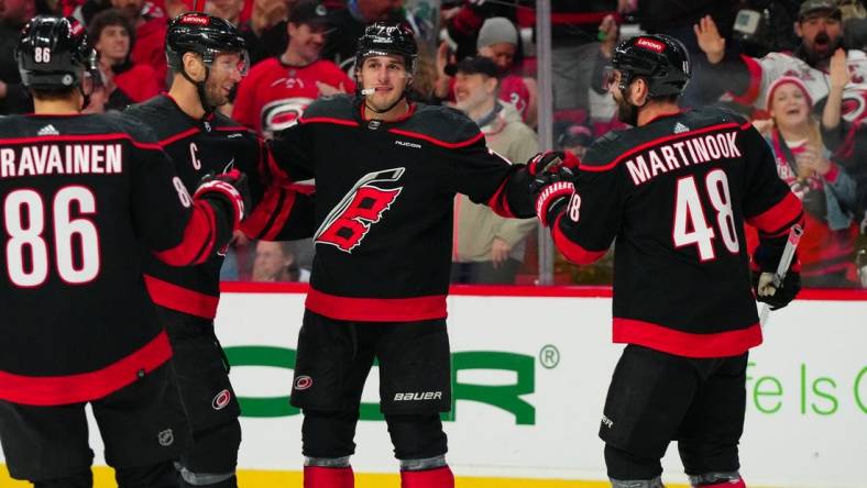 Mar 24, 2024; Raleigh, North Carolina, USA;  Carolina Hurricanes defenseman Brady Skjei (76) celebrates his goal with left wing Jordan Martinook (48) and center Jordan Staal (11) against the Toronto Maple Leafs during the first period at PNC Arena. Mandatory Credit: James Guillory-USA TODAY Sports