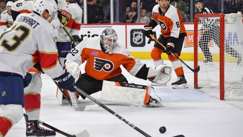 Mar 24, 2024; Philadelphia, Pennsylvania, USA; Philadelphia Flyers goaltender Felix Sandstrom (32) defends as Florida Panthers center Sam Reinhart (13) reaches for the puck during the second period at Wells Fargo Center. Mandatory Credit: Eric Hartline-USA TODAY Sports