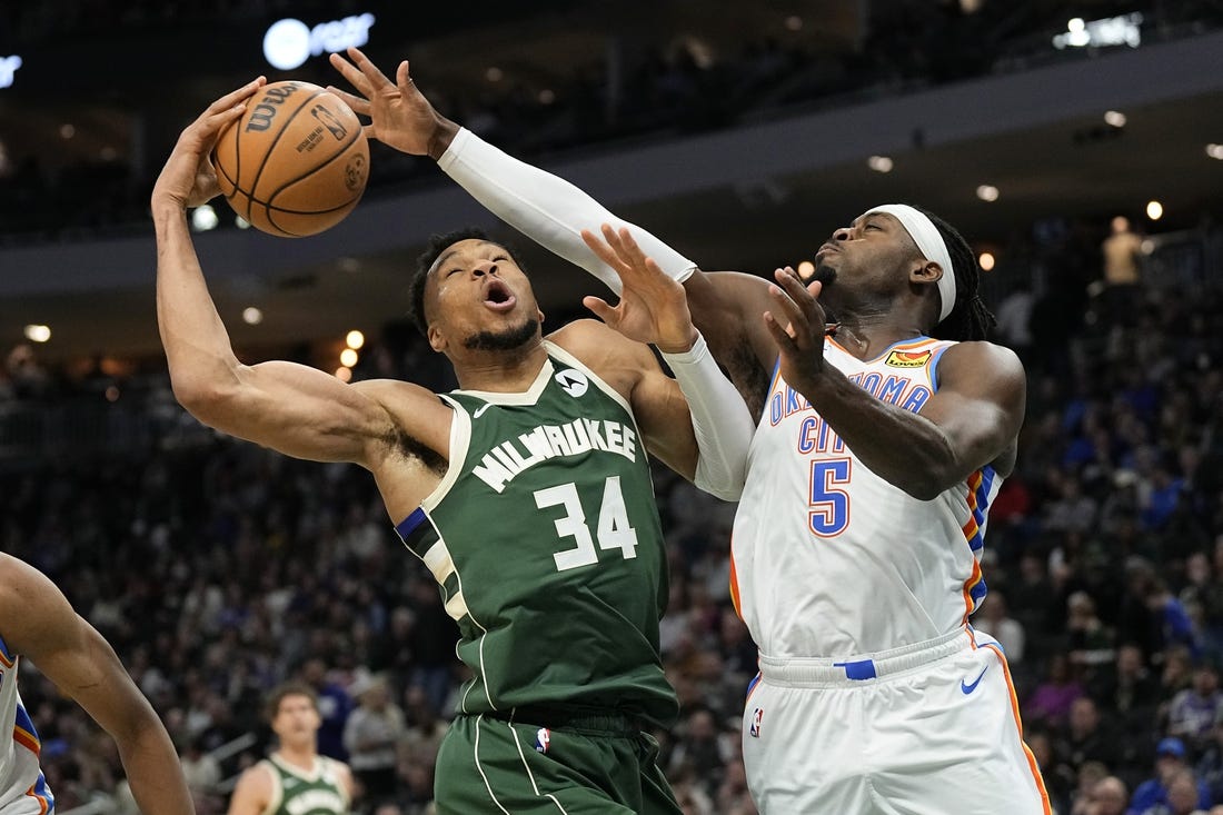 Mar 24, 2024; Milwaukee, Wisconsin, USA;  Milwaukee Bucks forward Giannis Antetokounmpo (34) and Oklahoma City Thunder forward Luguentz Dort (5) reach for a rebound during the third quarter at Fiserv Forum. Mandatory Credit: Jeff Hanisch-USA TODAY Sports