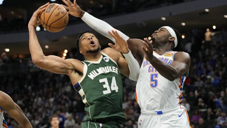 Mar 24, 2024; Milwaukee, Wisconsin, USA;  Milwaukee Bucks forward Giannis Antetokounmpo (34) and Oklahoma City Thunder forward Luguentz Dort (5) reach for a rebound during the third quarter at Fiserv Forum. Mandatory Credit: Jeff Hanisch-USA TODAY Sports