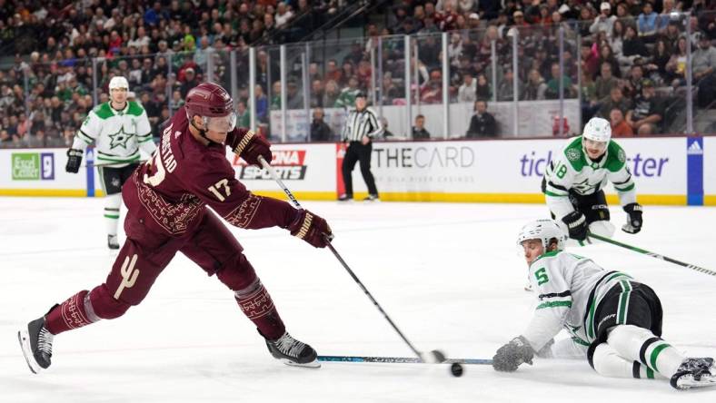 Mar 24, 2024; Tempe, Arizona, USA; Arizona Coyotes center Nick Bjugstad (17) shoots the puck by Dallas Stars defenseman Nils Lundkvist (5) during the second period at Mullett Arena. Mandatory Credit: Joe Camporeale-USA TODAY Sports