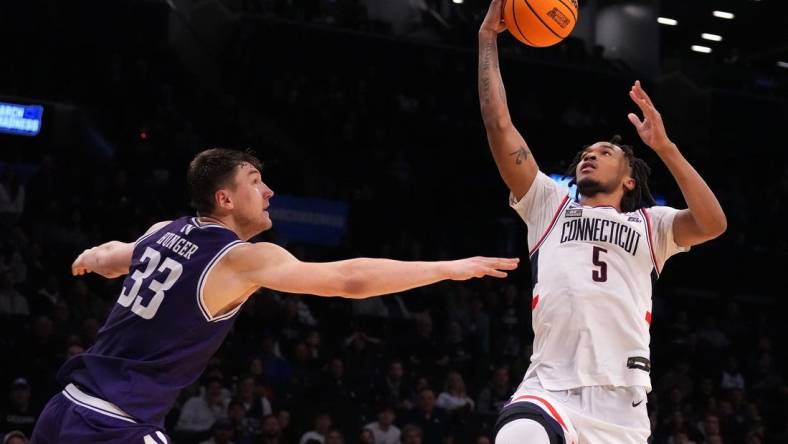 Mar 24, 2024; Brooklyn, NY, USA; Connecticut Huskies guard Stephon Castle (5) shoots the ball over Northwestern Wildcats forward Luke Hunger (33) in the second round of the 2024 NCAA Tournament at the Barclays Center. Mandatory Credit: Robert Deutsch-USA TODAY Sports