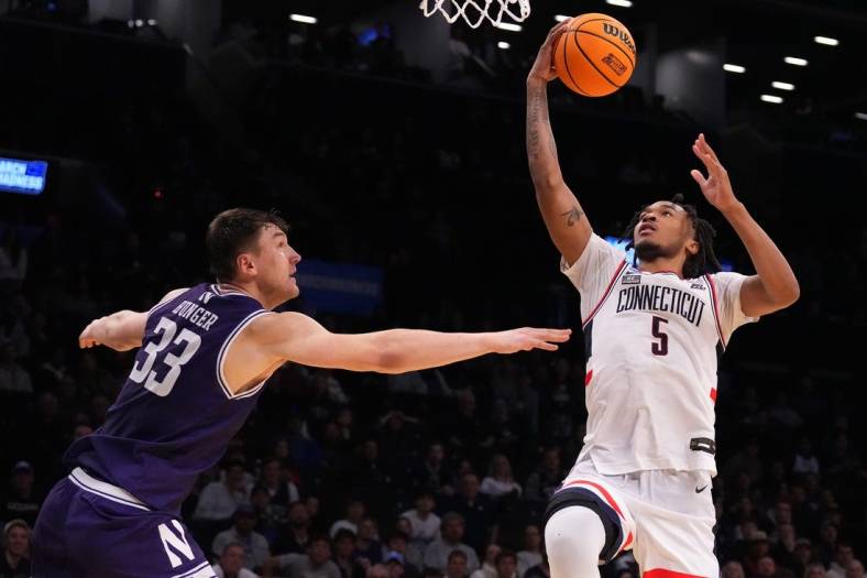 Mar 24, 2024; Brooklyn, NY, USA; Connecticut Huskies guard Stephon Castle (5) shoots the ball over Northwestern Wildcats forward Luke Hunger (33) in the second round of the 2024 NCAA Tournament at the Barclays Center. Mandatory Credit: Robert Deutsch-USA TODAY Sports