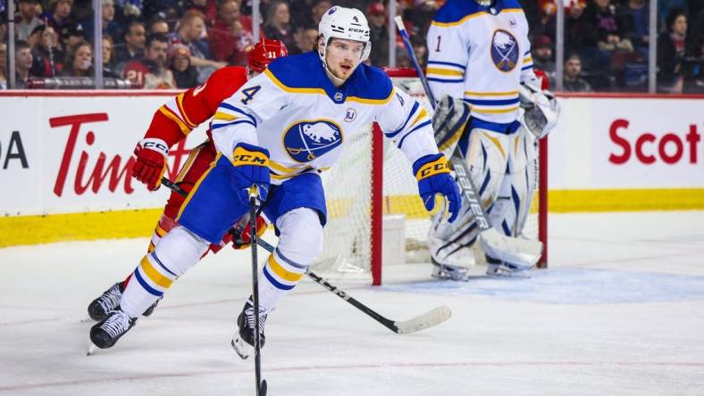 Mar 24, 2024; Calgary, Alberta, CAN; Buffalo Sabres defenseman Bowen Byram (4) controls the puck against the Calgary Flames during the second period at Scotiabank Saddledome. Mandatory Credit: Sergei Belski-USA TODAY Sports