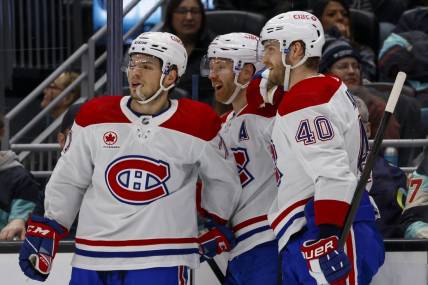 Mar 24, 2024; Seattle, Washington, USA; Montreal Canadiens defenseman Mike Matheson (8) celebrates with center Jake Evans (71, left) and right wing Joel Armia (40) after scoring a goal against the Seattle Kraken during the second period at Climate Pledge Arena. Mandatory Credit: Joe Nicholson-USA TODAY Sports