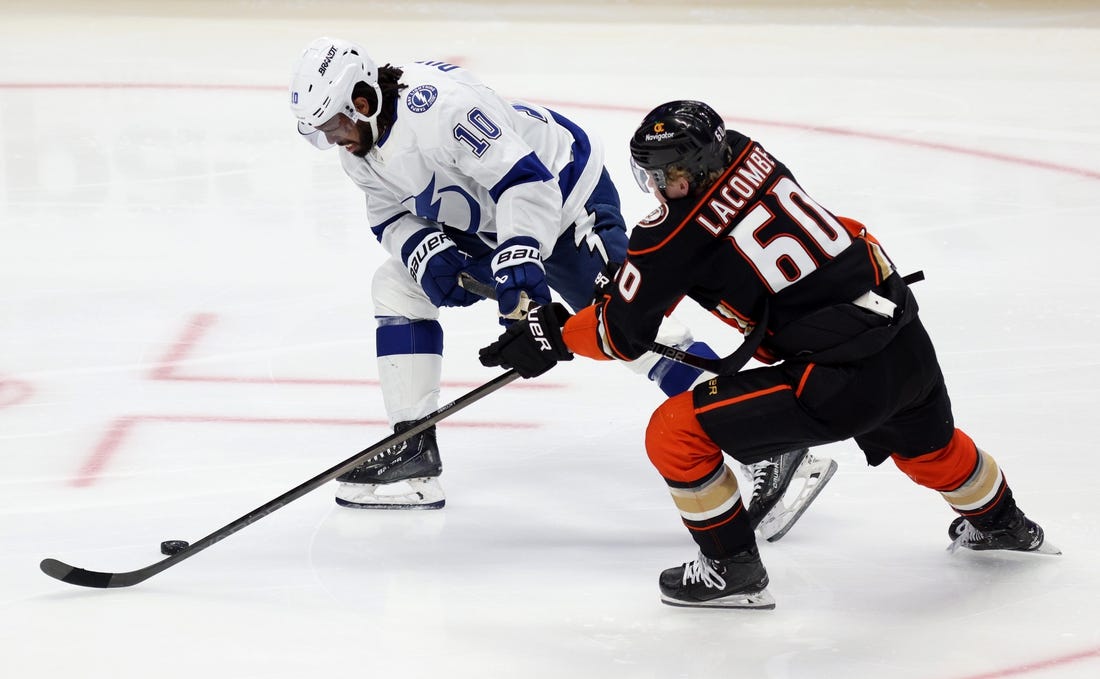 Mar 24, 2024; Anaheim, California, USA; Tampa Bay Lightning left wing Anthony Duclair (10) and Anaheim Ducks defenseman Jackson LaCombe (60) chase the puck during the third period at Honda Center. Mandatory Credit: Jason Parkhurst-USA TODAY Sports