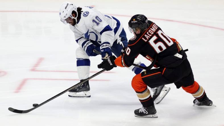 Mar 24, 2024; Anaheim, California, USA; Tampa Bay Lightning left wing Anthony Duclair (10) and Anaheim Ducks defenseman Jackson LaCombe (60) chase the puck during the third period at Honda Center. Mandatory Credit: Jason Parkhurst-USA TODAY Sports